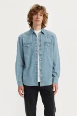 Camisa de denim celeste de calce recto, con cuello clásico, cierre con botones a presión, mangas largas con puños abotonados, dos bolsillos con solapa abotonada en el pecho y canesú en la parte delantera y trasera.