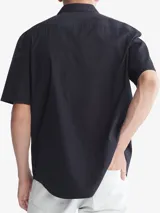 Camisa manga corta de algodón color negro, con cierre frontal de botones y bolsillo en el pecho, diseñada para transpiración.