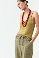 Pantalón color verde oliva de tiro alto, corte ancho y largo 7/8. Tiene cintura elástica ajustable con cordón, bolsillos de plastrón en delantero y espalda.