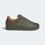 Championes urbanos Adidas Superstar II de color verde militar con forro interno naranja. Cuentan con un exterior de cuero con detalles de nylon abullonado, la clásica puntera de goma con relieve y suela de caucho a tono.