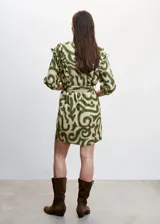 Vestido corto con estampado verde y detalles de volantes, de manga tres cuartos y diseño cruzado.
