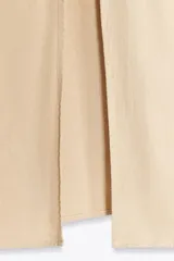 Vestido midi color beige confeccionado en lino, con tirantes finos ajustables, escote en pico con detalle de crochet y jaretas, abertura frontal y cierre lateral con cremallera oculta.