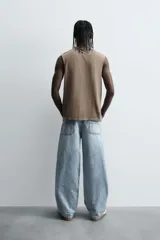 Pantalón de denim de algodón, color celeste claro lavado, de corte relaxed fit con tiro alto, bolsillos frontales y bolsillos traseros de plastrón.