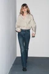 Pantalón de jean azul oscuro, de tiro bajo, corte slim fit y bootcut. Con cinco bolsillos y cierre frontal con cremallera y botón.