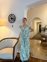 Vestido largo con estampado de cebra en tonos verde y blanco, con escote en V y mangas cortas con volados. Corte holgado.