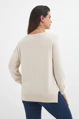 Sweater lila de tejido de punto, con escote en V y mangas largas.