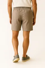 Short de lino color verde militar, con cintura elástica y cordón ajustable, bolsillos laterales y corte ancho.