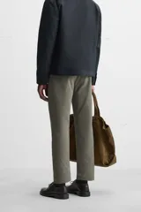 Pantalón chino negro slim fit confeccionado en tejido técnico de secado rápido. Cuenta con bolsillos frontales y traseros de vivo. Cierre frontal con cremallera y botón.
