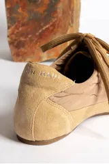 Zapatillas deportivas verde oliva con cordones y suela marrón.