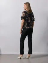 Blusa de gasa estampada con cuello a la base y escote en V. Tiene mangas cortas amplias con sobrecapas.