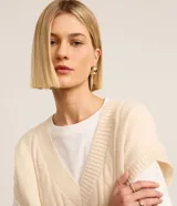 Chaleco gris de punto con escote en V y textura de trenzas.