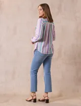 Blusa de lino estampada a rayas verticales de colores blanco, verde, lila, amarillo y rosa. Tiene cuello a la base con escote en V y abertura central con botones. Cuenta con dos bolsillos frontales y mangas largas regulables con presilla y botón. Marca Zac & Rachel.