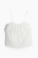 Top blanco de encaje con breteles finos y escote recto con volado festoneado.