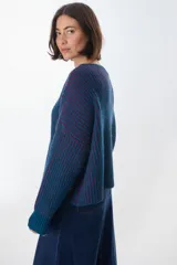 Sweater de punto grueso a rayas verticales en color azul petróleo y borgoña, de corte holgado y mangas largas.