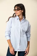 Camisa de manga larga a rayas verticales color violeta y blanco, con cuello clásico y corte recto.