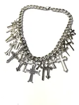 Collar plateado de cadena gruesa con dijes colgantes de cruces de diferentes estilos.