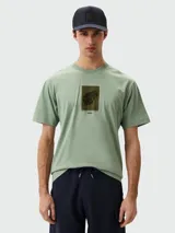 Remera verde oliva de algodón con estampado de hoja enmarcada en color verde oscuro y logo de la marca BOSS en la parte inferior.