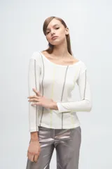 Remera gris de corte ajustado, con cuello redondo y mangas largas. Presenta líneas verticales bordadas en color verde claro y blanco.