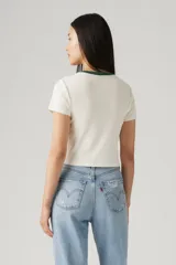 Remera blanca de algodón con cuello redondo ribeteado en verde y estampa de paisaje con sol en tonos naranja, verde y marrón.