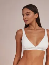 Soutien halter blanco de algodón con breteles finos y detalle de puntilla en escote y breteles.