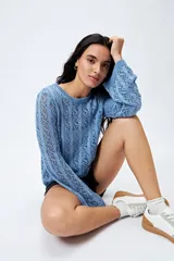 Sweater calado celeste con escote redondo y mangas largas acampanadas, tejido en punto fantasía con dibujo vertical.