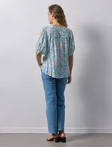 Blusa de gasa estampada con cuello en V, mangas cortas abullonadas con puño y terminación anudada en la parte delantera.