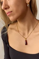 Collar dorado con cadena fina y dije en forma de lágrima de piedra ojo de tigre.
