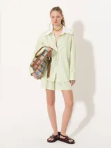 Short amarillo de tiro alto con pinzas delanteras y cierre invisible lateral.