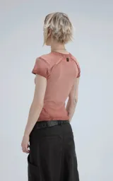 Remera de manga corta, cuello redondo, confeccionada en tejido ribb 100% algodón. Diseño ajustado al cuerpo con largo a la cadera. Presenta un tono rosado desgastado y costuras expuestas en hombros y laterales.