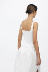 Vestido midi rojo de escote cuadrado y tirantes anchos. Detalle de bajo redondeado en tejido combinado a tono.