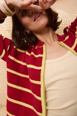 Campera con cierre frontal, de tejido con ondas y rayas horizontales verdes, rojas y negras.