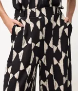 Pantalón de mujer modelo wide leg, con cintura elástica y estampado abstracto en blanco y negro. Confeccionado en tejido piqué de viscosa certificada.