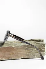 Lentes de sol unisex con montura redonda negra y lentes degradadas de gris a transparente.