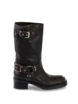 Bota de cuero negra de media caña con hebillas plateadas en el tobillo y en la parte superior de la caña.