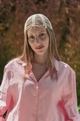 Gorro tejido a crochet color crema con monedas doradas colgando.