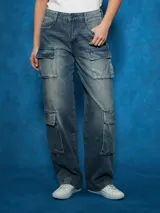 Pantalón de jean cargo de tiro alto, color azul medio desgastado, con corte ancho y bolsillos cargo a los lados de las piernas.