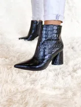 Botas cortas color marrón con estampado de cocodrilo, punta fina y taco de 8.5 cm.