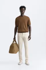 Pantalón chino azul marino, corte skinny fit, confeccionado en tejido de algodón con elasticidad. Cuenta con bolsillos frontales y traseros de vivo. Cierre frontal con cremallera y botón.
