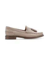 Mocasín de cuero color beige, con borlas ornamentales y puntadas artesanales.