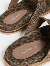 Sandalia tipo ojota de cuero negro con diseño de tira central con nudo y base de corcho.