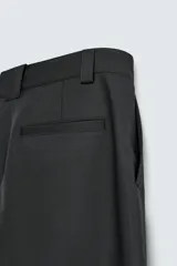 Pantalón negro de corte recto, con bolsillos frontales tipo parche y bolsillos traseros de ojal.