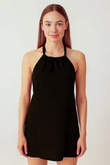 Vestido mini negro de lino y viscosa, con cuello halter y cordón ajustable.