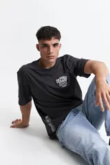 Remera negra de algodón con corte oversize, mangas cortas y cuello redondo. Estampa frontal con texto 'Explore Discover Grow' y logo de la marca Mistral.
