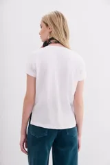 Remera blanca de algodón peruano, de corte ajustado y escote en V pronunciado.