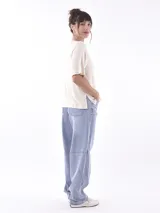 Remera blanca de manga corta con cuello redondo y estampado frontal que dice "SAVAGE" con una figura de animal (posiblemente un leopardo o jaguar) hecho de lentejuelas o material brillante. Debajo del estampado principal se lee "LIFE GOES ON ENJOY".