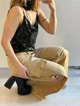 Musculosa negra con lentejuelas y tirantes finos.
