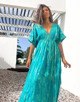 Túnica larga color turquesa con estampado de arabescos dorados, escote en V y mangas cortas.