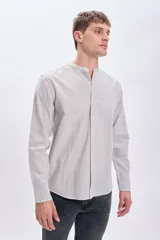 Camisa de manga larga con cuello mao y cierre frontal con botones. Diseño a rayas verticales en tonos blanco y marrón.