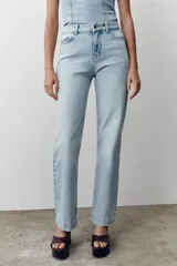 Pantalón de jean celeste de corte recto y largo, con tiro medio y cinco bolsillos.