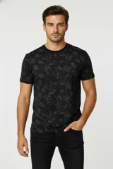 Remera de algodón negra con estampado floral en tonos grises, cuello redondo y manga corta, corte holgado.